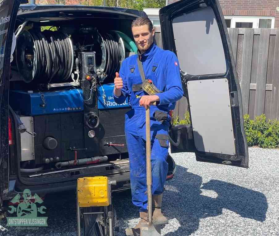 Een tevreden monteur met opgestoken duim naast de bestelbus, slim ingrijpen bespaart kosten bij een verstopte afvoer in Vlissingen