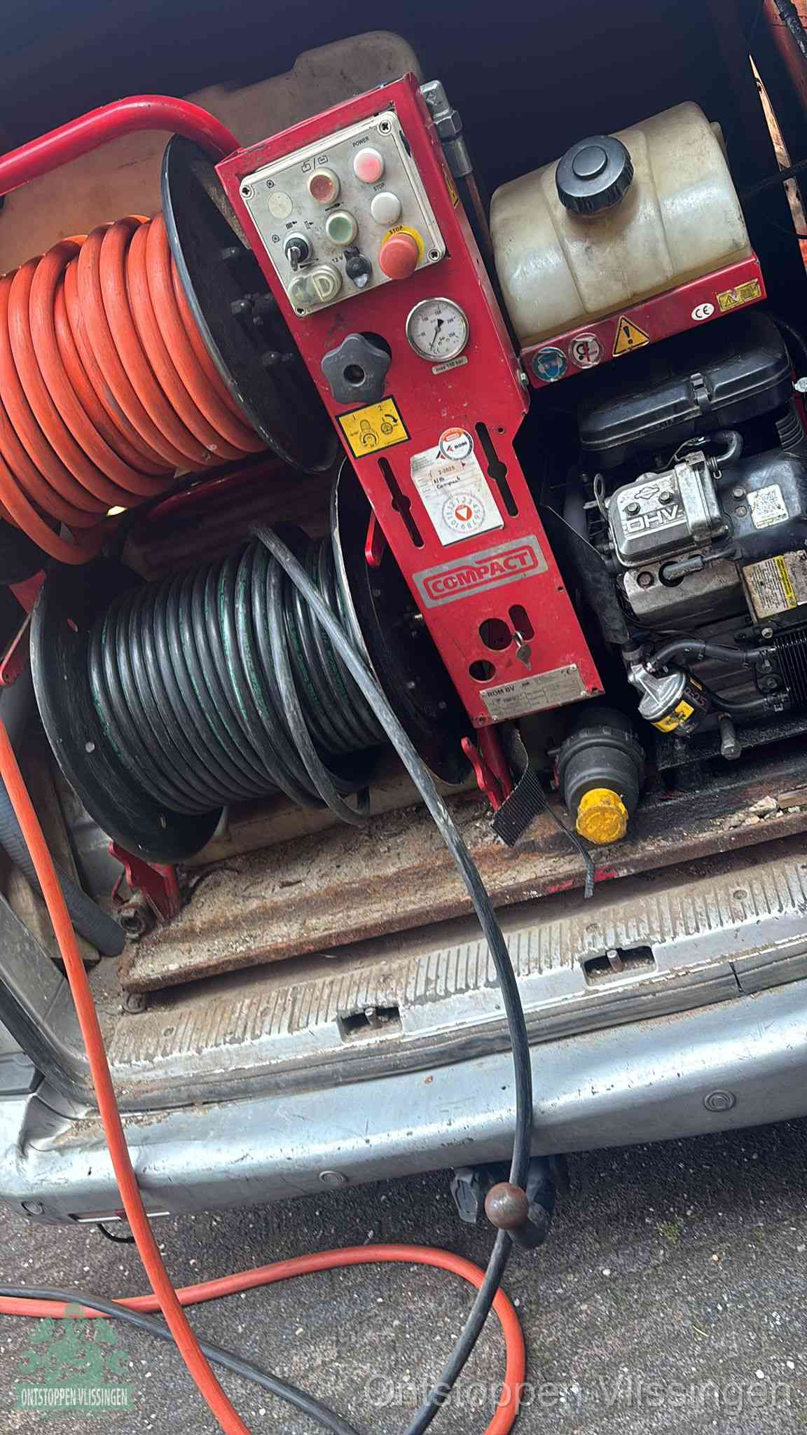 Een rood hogedruk-rioolreinigingstoestel in de laadbak van de bedrijfsbus, apparatuur voor een hardnekkige afvoerverstopping in Vlissingen