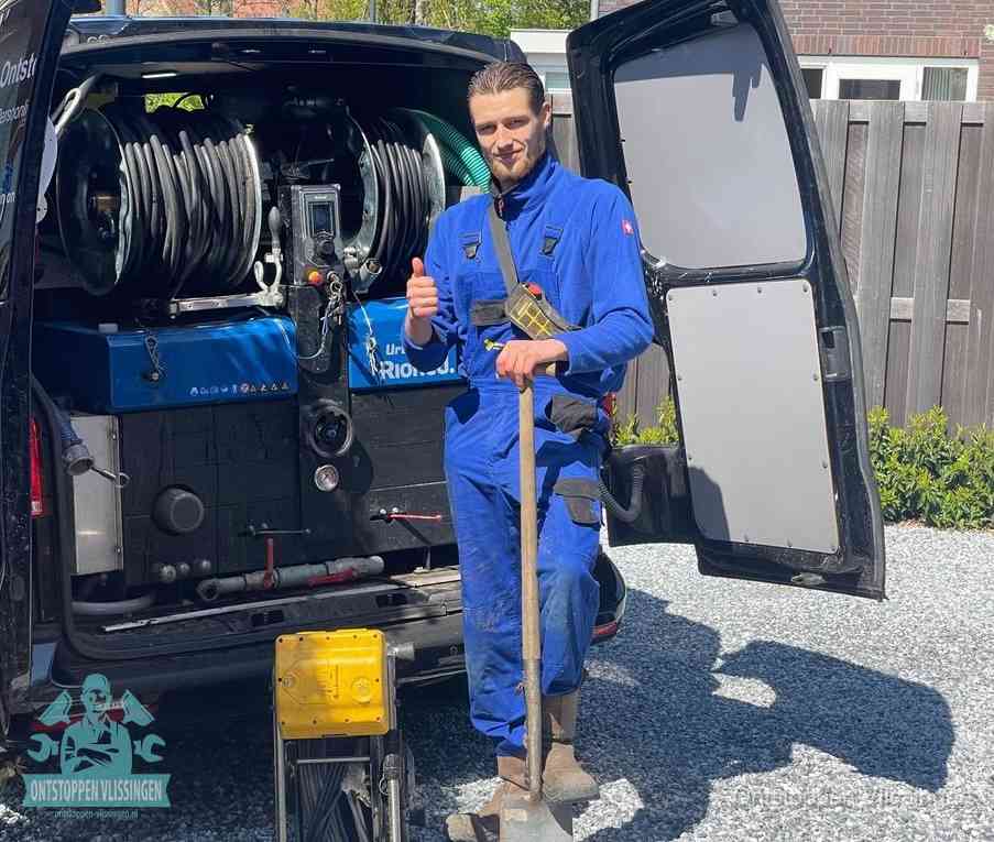 Een monteur bij de werkbus met grote hogedruk-slanghaspels, apparatuur voor hardnekkige afvoerverstoppingen in Vlissingen