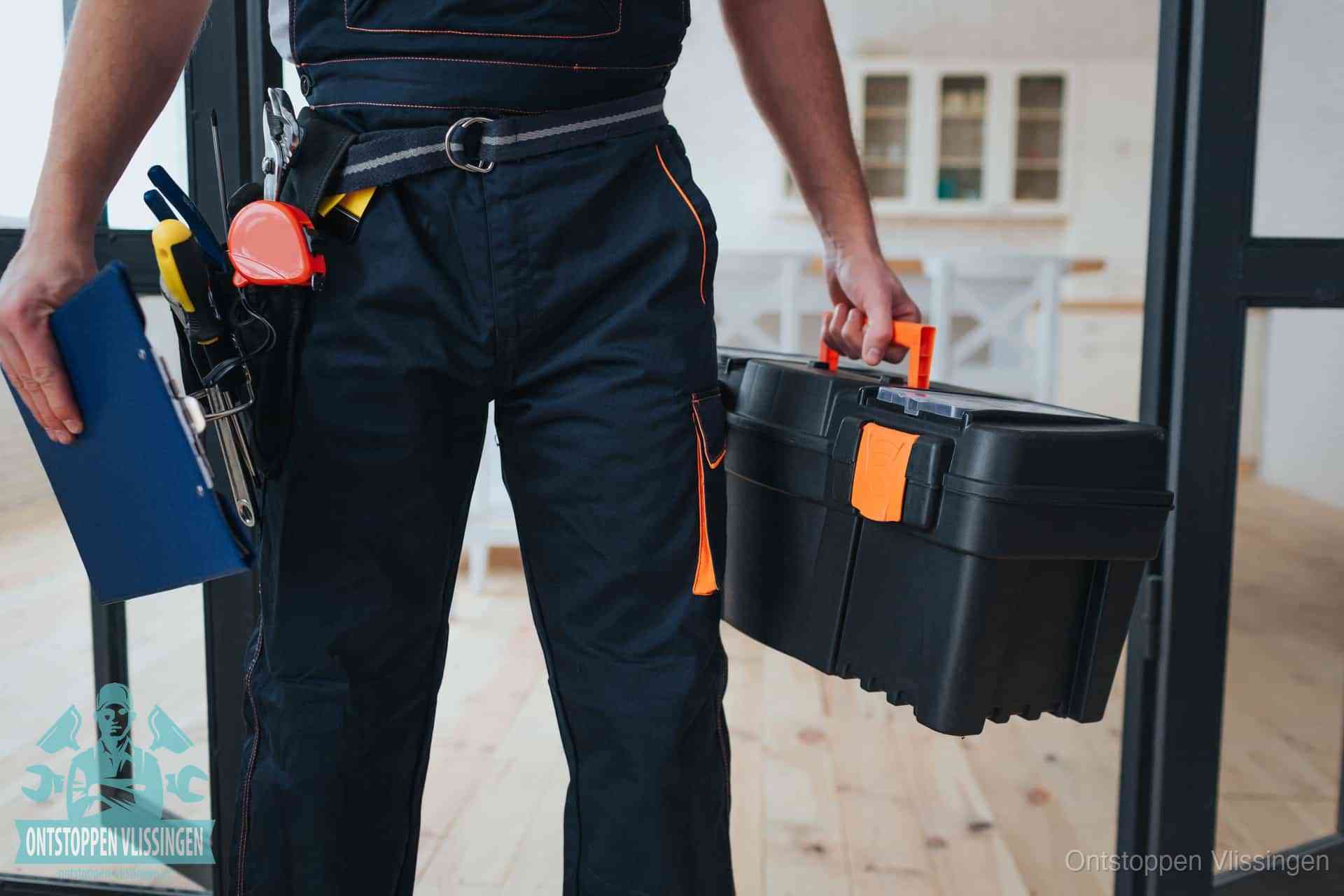 Een monteur met gereedschapsriem en klembord in een keuken, klaar om een transparante prijs voor het gootsteen ontstoppen in Vlissingen te geven