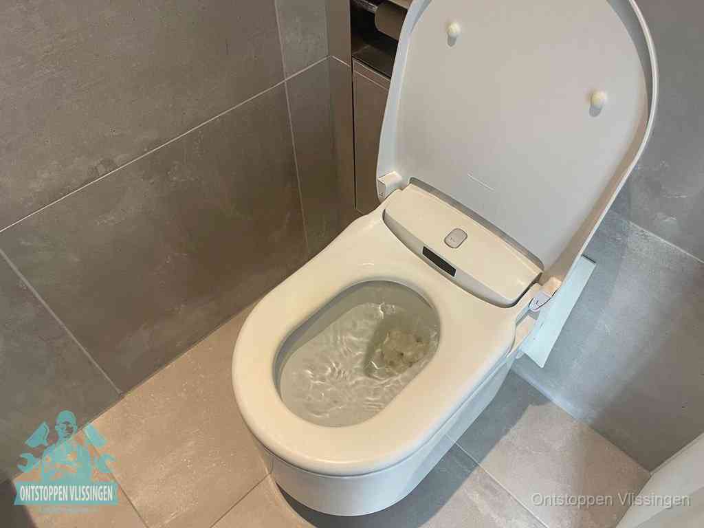 Een toiletpot vol troebel water met drijvend papier en restanten, de meest voorkomende oorzaak van een verstopte wc in Vlissingen