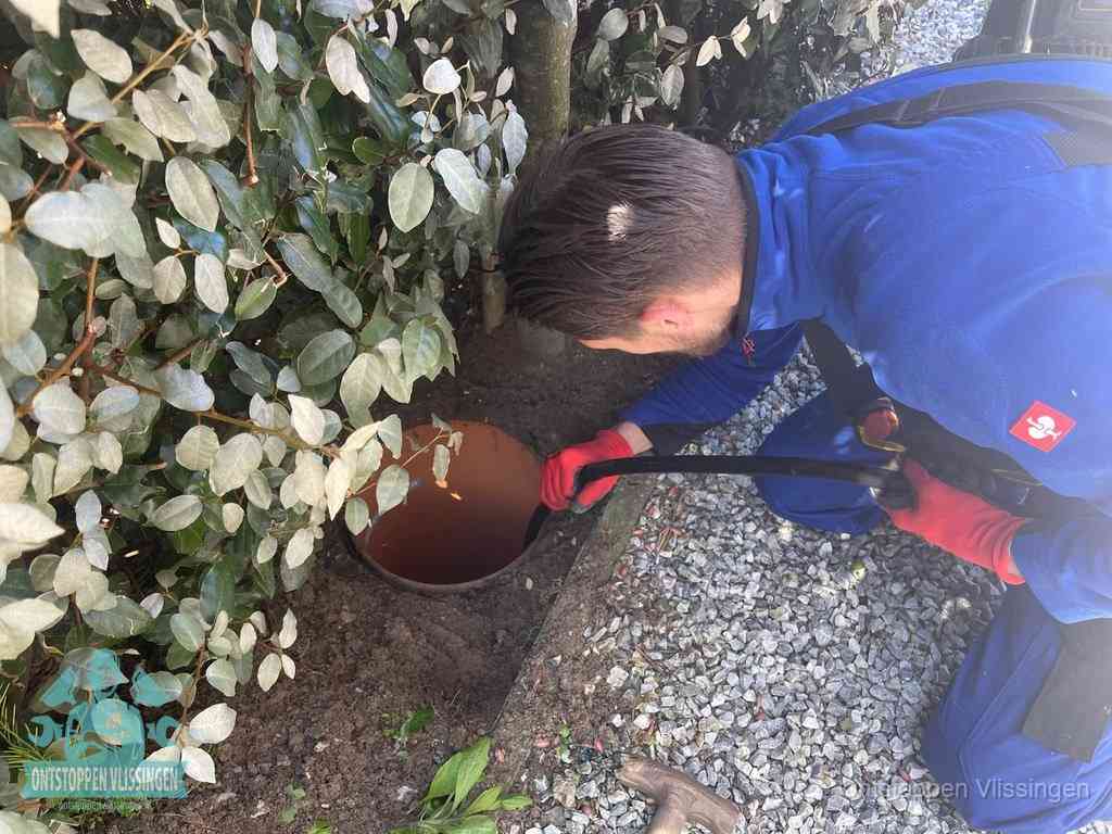 Monteur reinigt een rioolput met een slang, periodieke rioolreiniging in Vlissingen