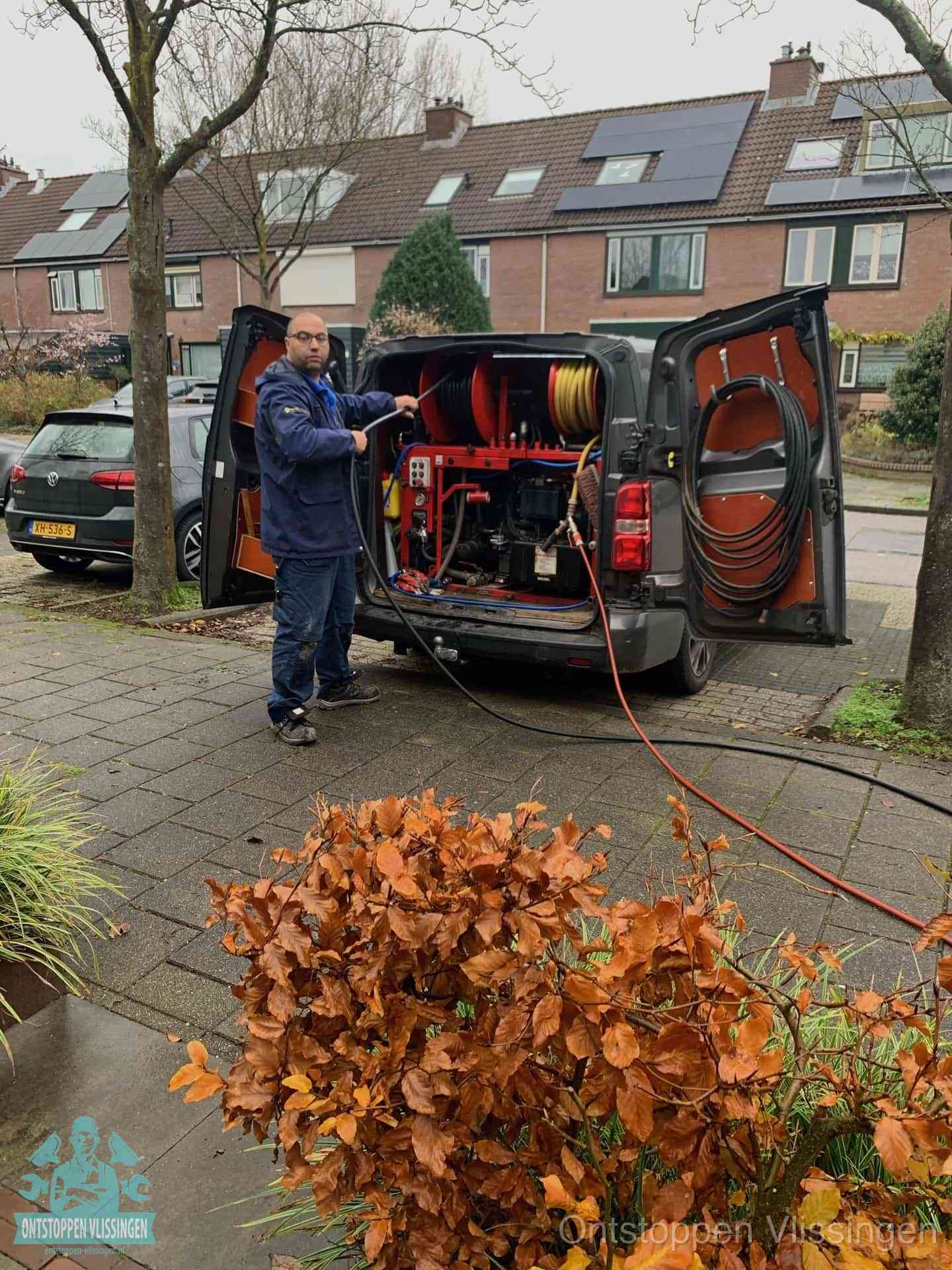 Monteur met rioolreinigingsbus levert rioolservice in de wijk in Vlissingen