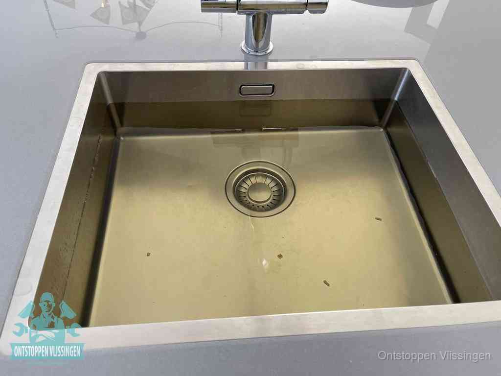 Stilstaand water in een rvs spoelbak dat niet wegloopt, een duidelijk signaal van een gootsteenverstopping in Vlissingen