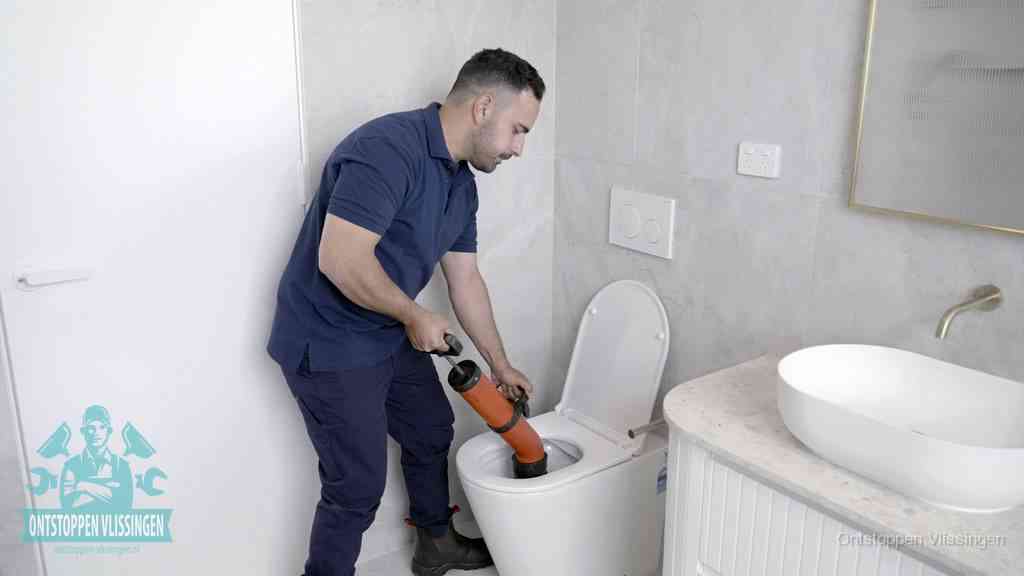 Een monteur gebruikt een handmatige perspomp (toiletontstopper) op een wandcloset tijdens het professioneel wc ontstoppen in Vlissingen